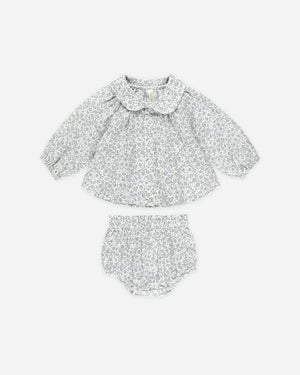 The Nellie set includes a fun and flowy shirt with a scalloped collar at the neck and button front detail and matching bloomers.

Featuring a floral print on dusty blue 